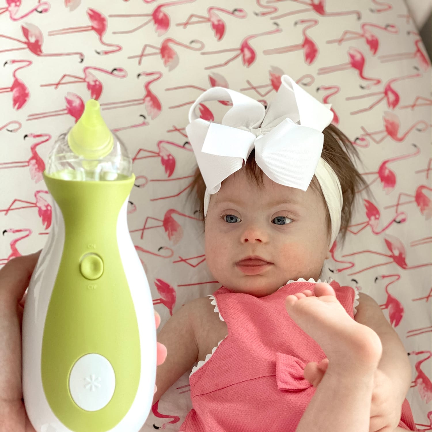 Une petite fille atteinte du syndrome de Down avec un mouche-bébé électrique portatif Nosiboo Go