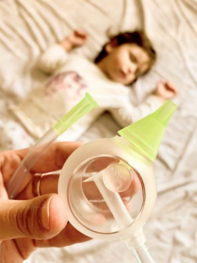 Quelqu'un tient un mouche-bébé manuel Nosiboo Eco au-dessus d'un enfant qui dort paisiblement